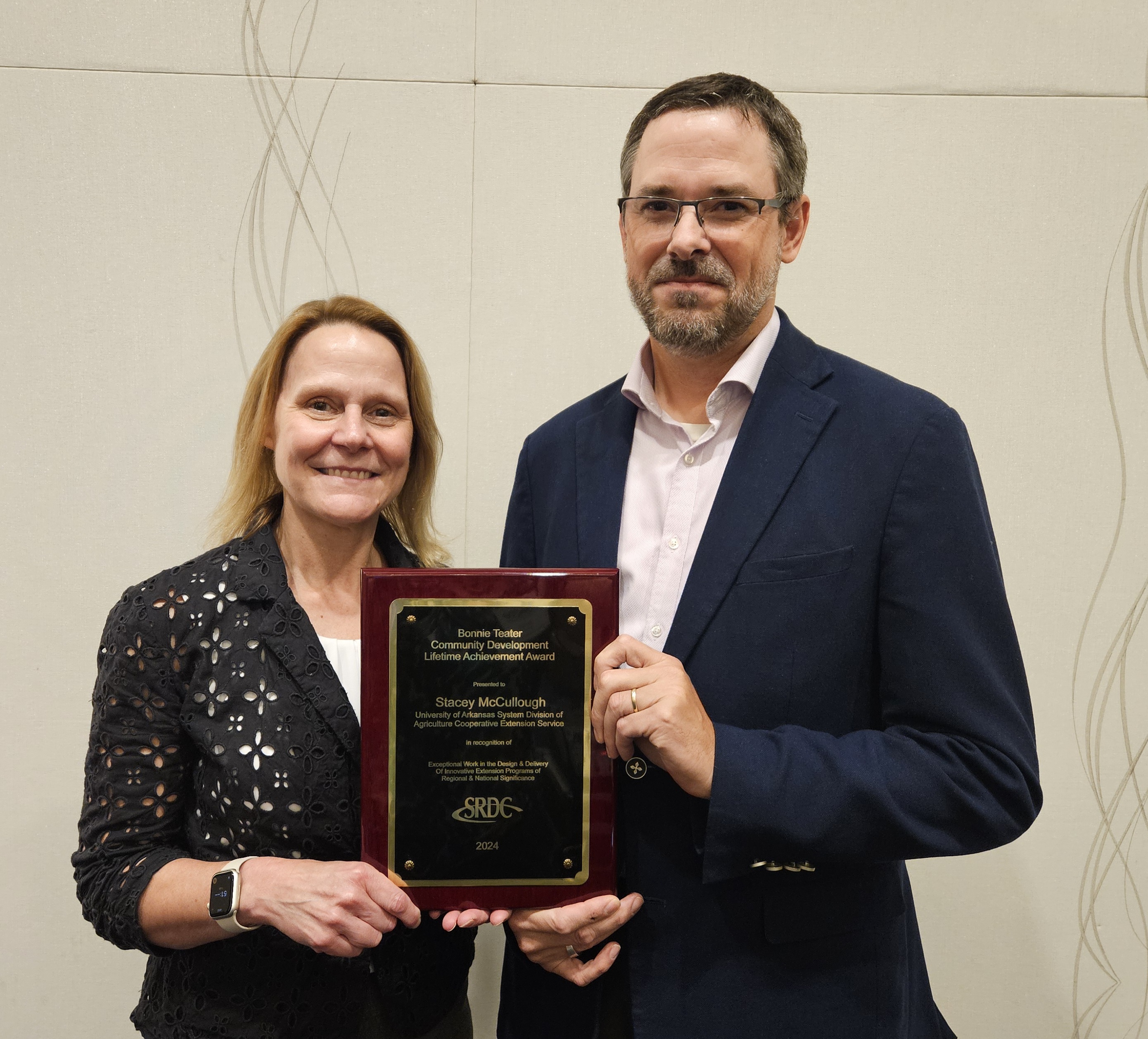 photo, stacey mccullough and john green holding plaque