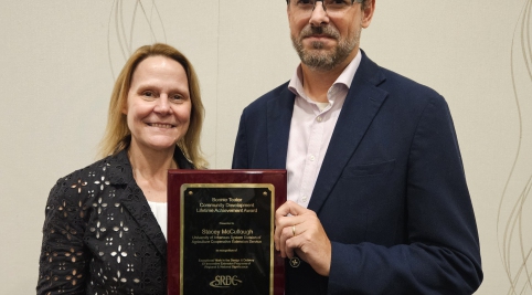 photo, stacey mccullough and john green holding plaque