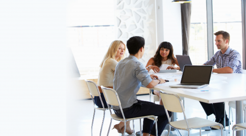 people sitting at table with laptops